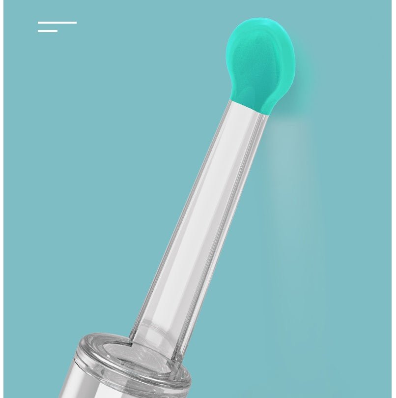 Clear ear picker with green silicone tip on a light blue background